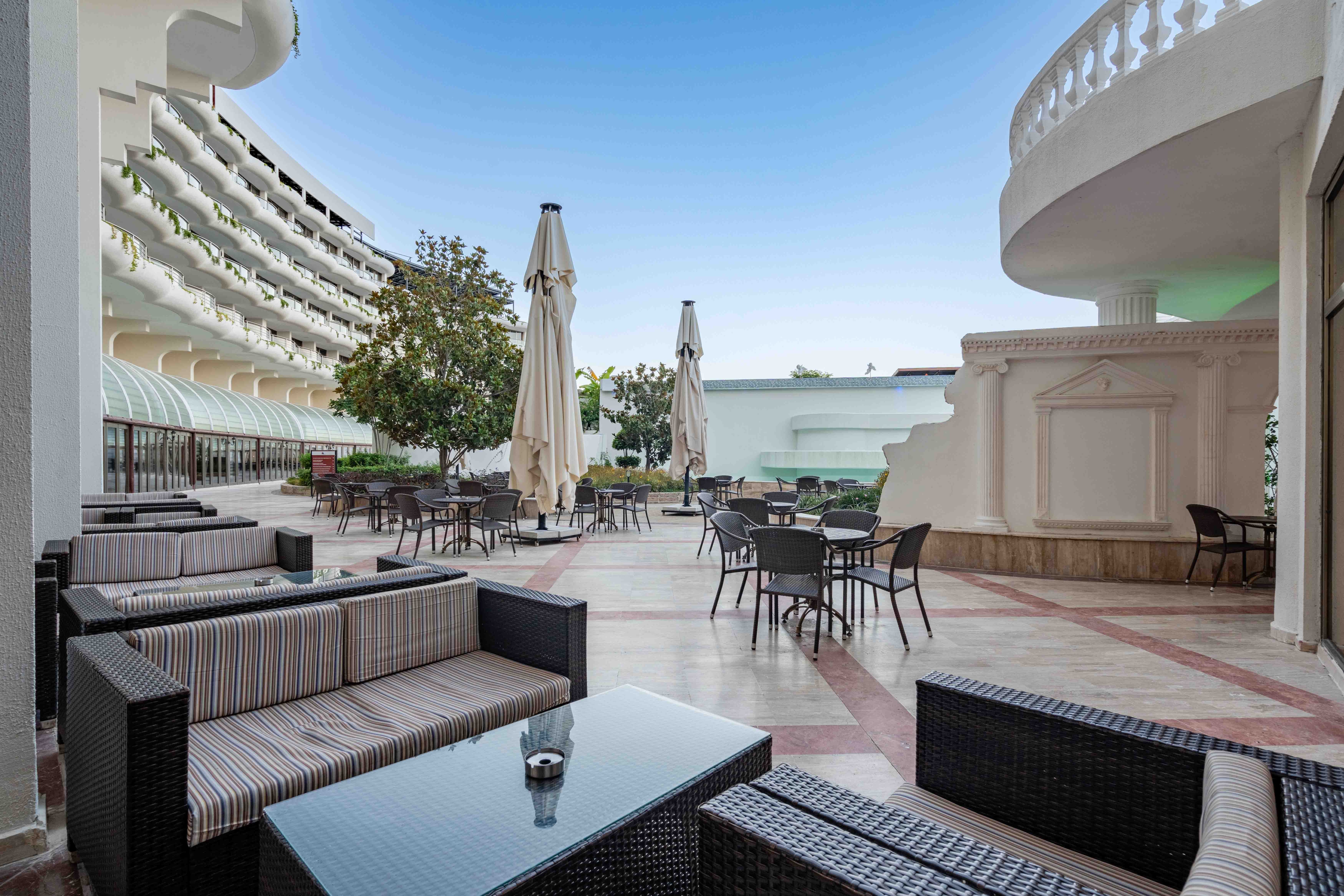 Outdoor terrace seating framed by white balconies.