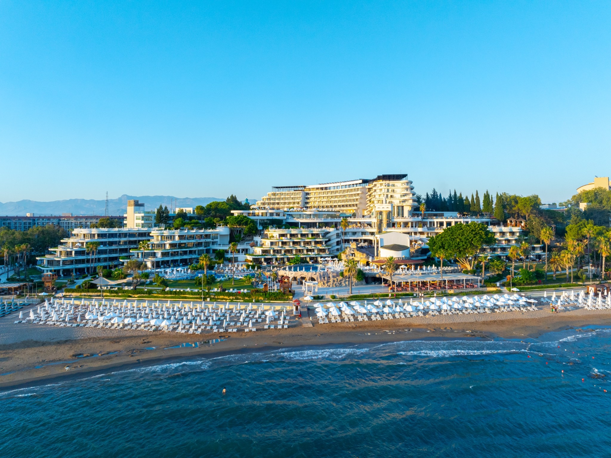 Terraced hotel buildings beside the Mediterranean Sea.