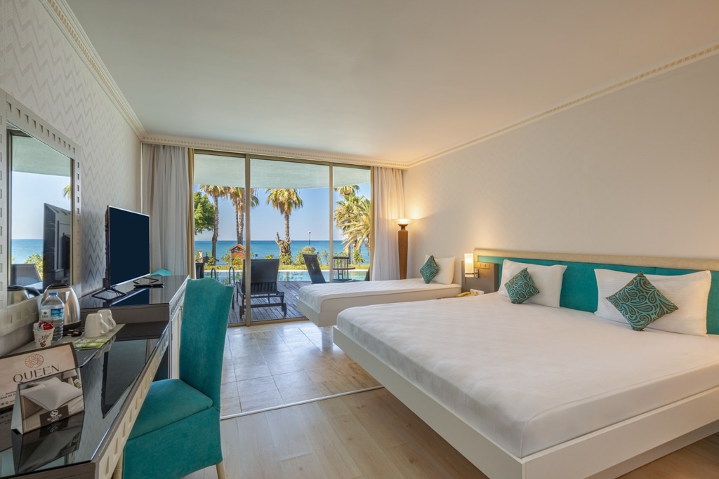 A swim-up room with beds, terrace seating and the pool beyond.
